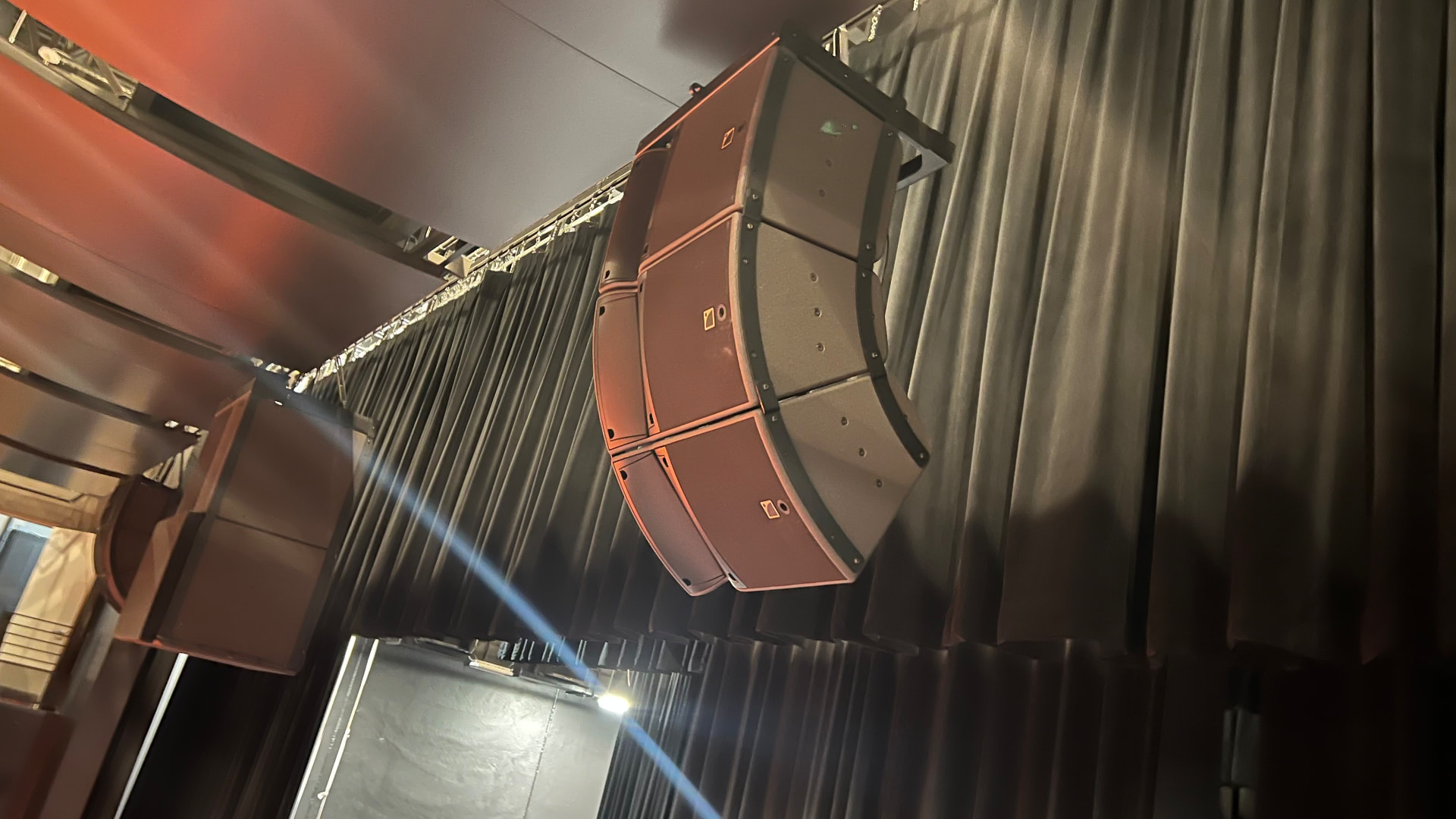 Flown line array at the proscenium with center cluster behind the main curtain.