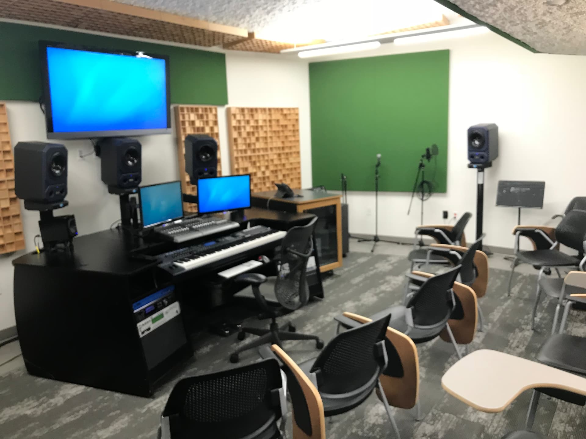 Instructional audio classroom and control suite with monitoring and live-capture positions.