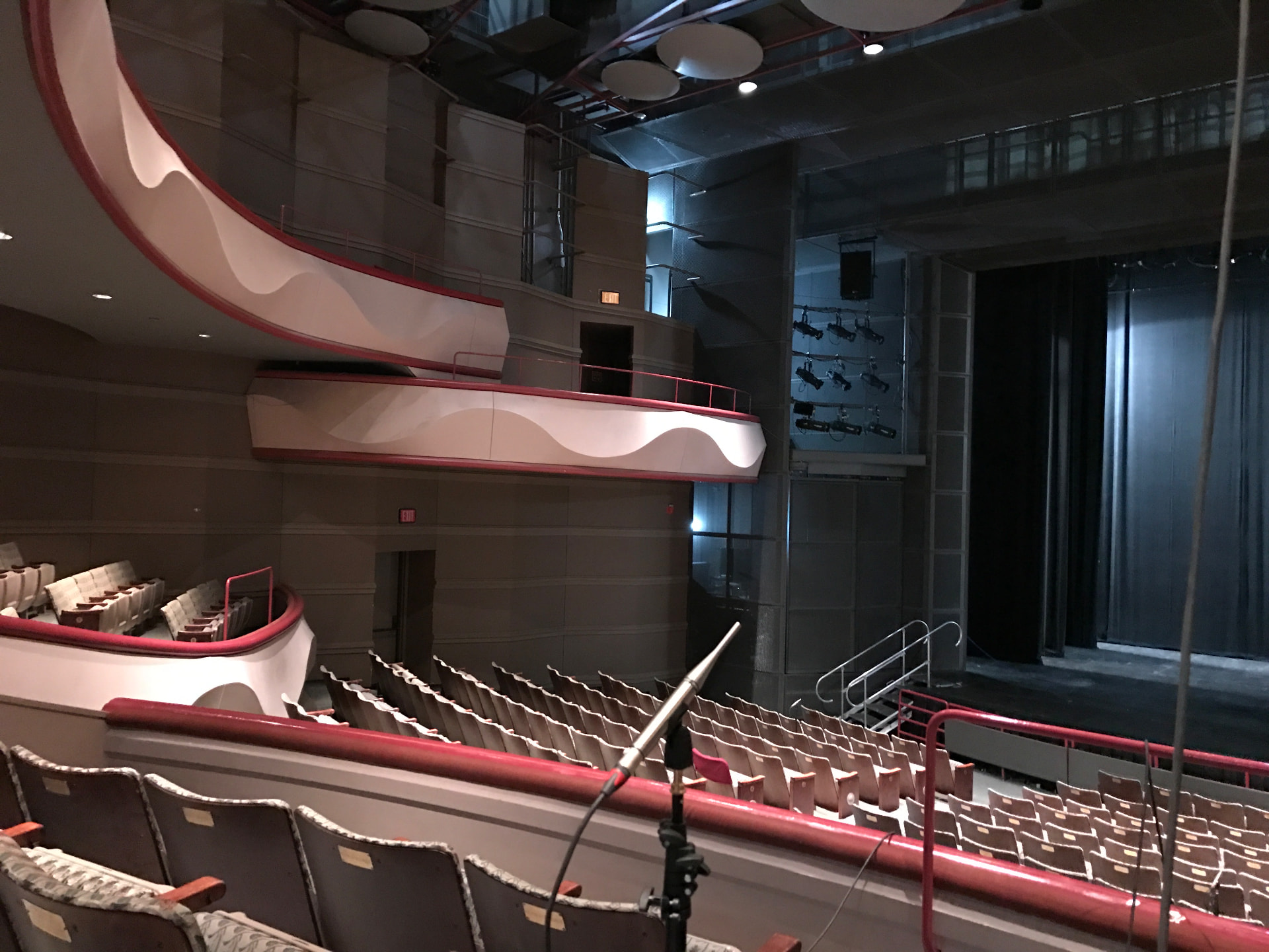 Side-balcony sightlines with a measurement mic staged for dual-FFT alignment of the retuned house system.