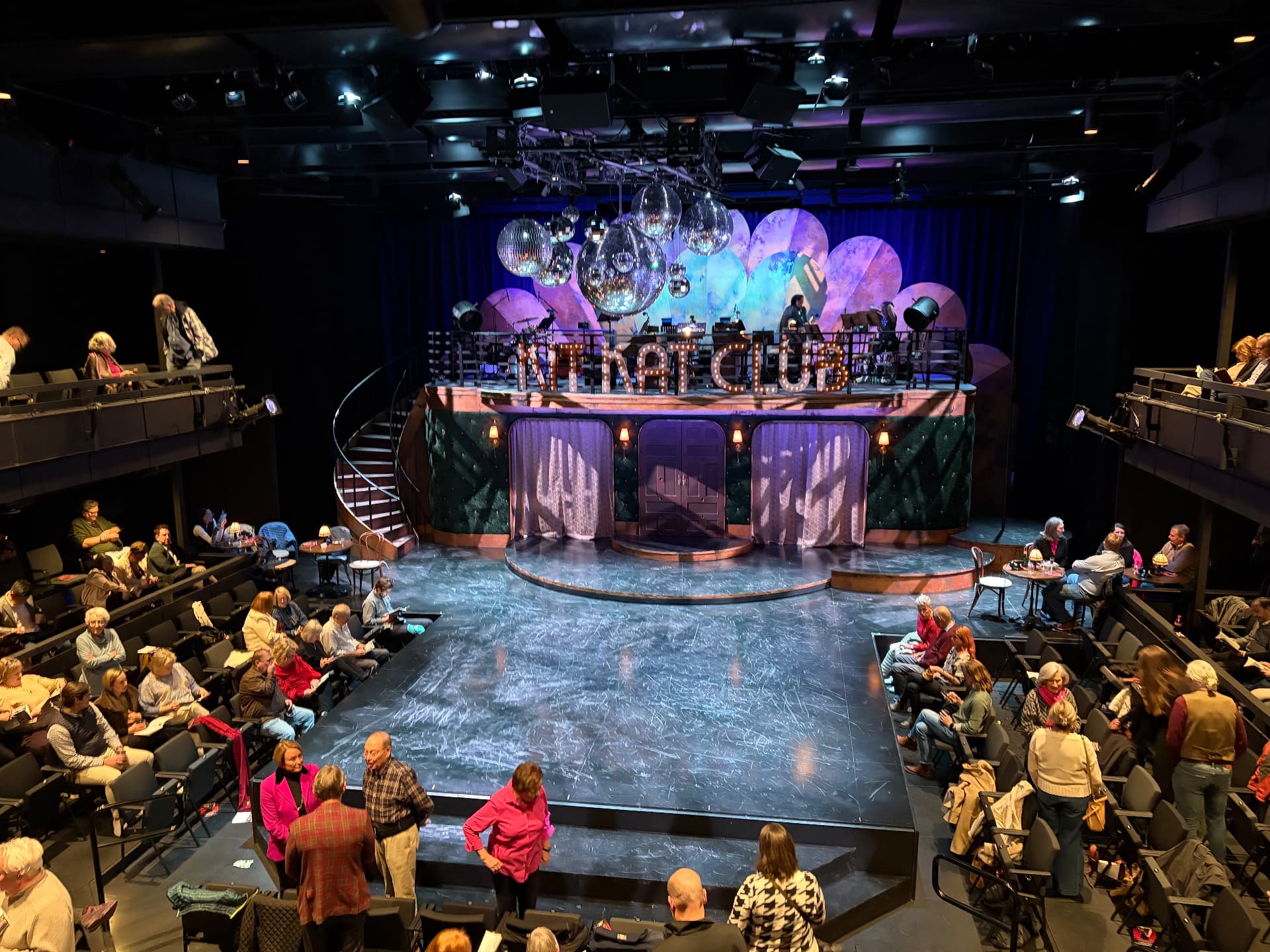 House in performance configuration — overhead reinforcement and production lighting grid above a full arena audience.