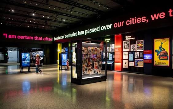 The Arts and Ideals gallery — LED text frieze wrapping the upper volume above the interactive stations.
