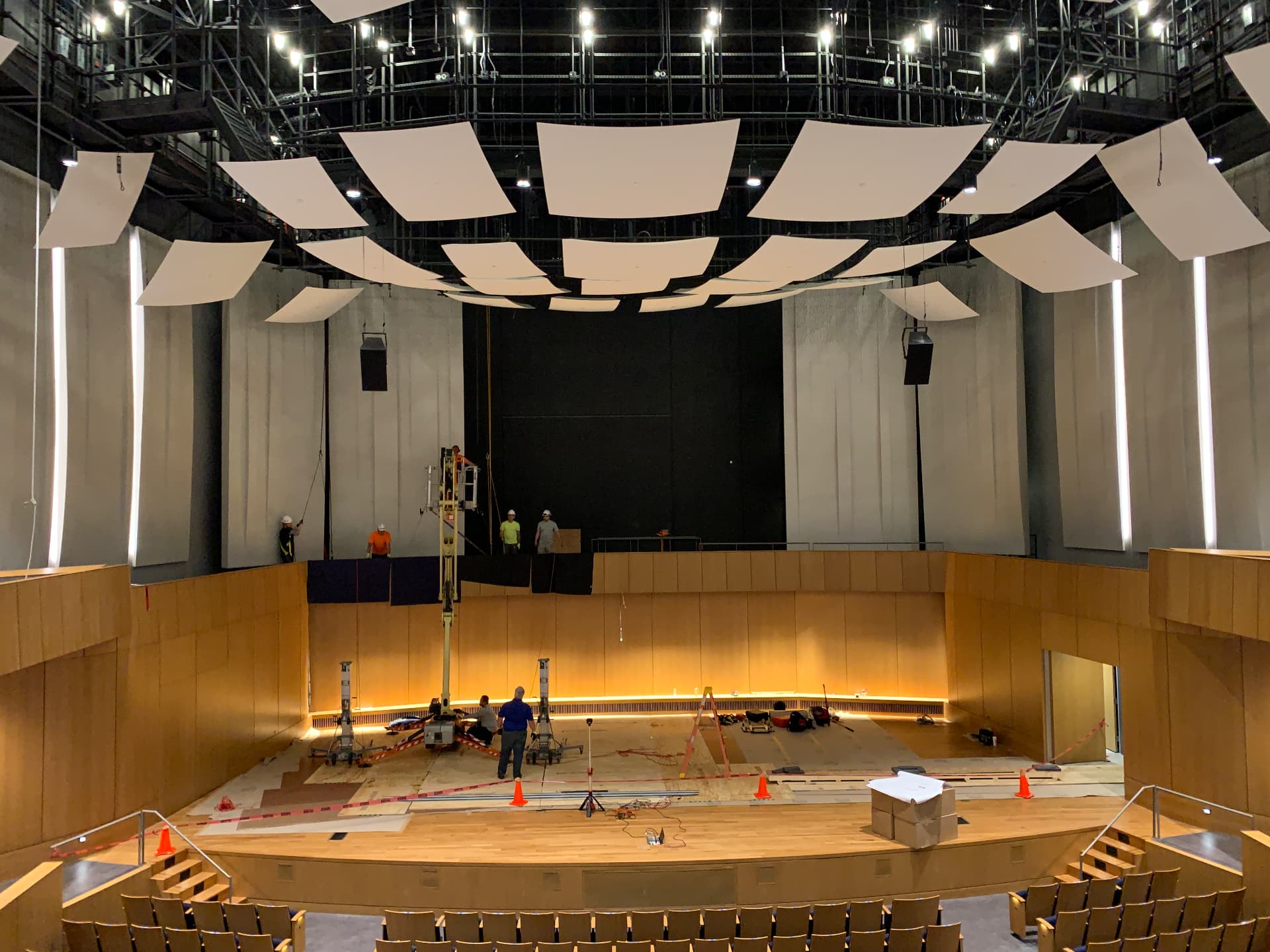 Concert hall under construction — reflector cloud and stage fit-out in progress.