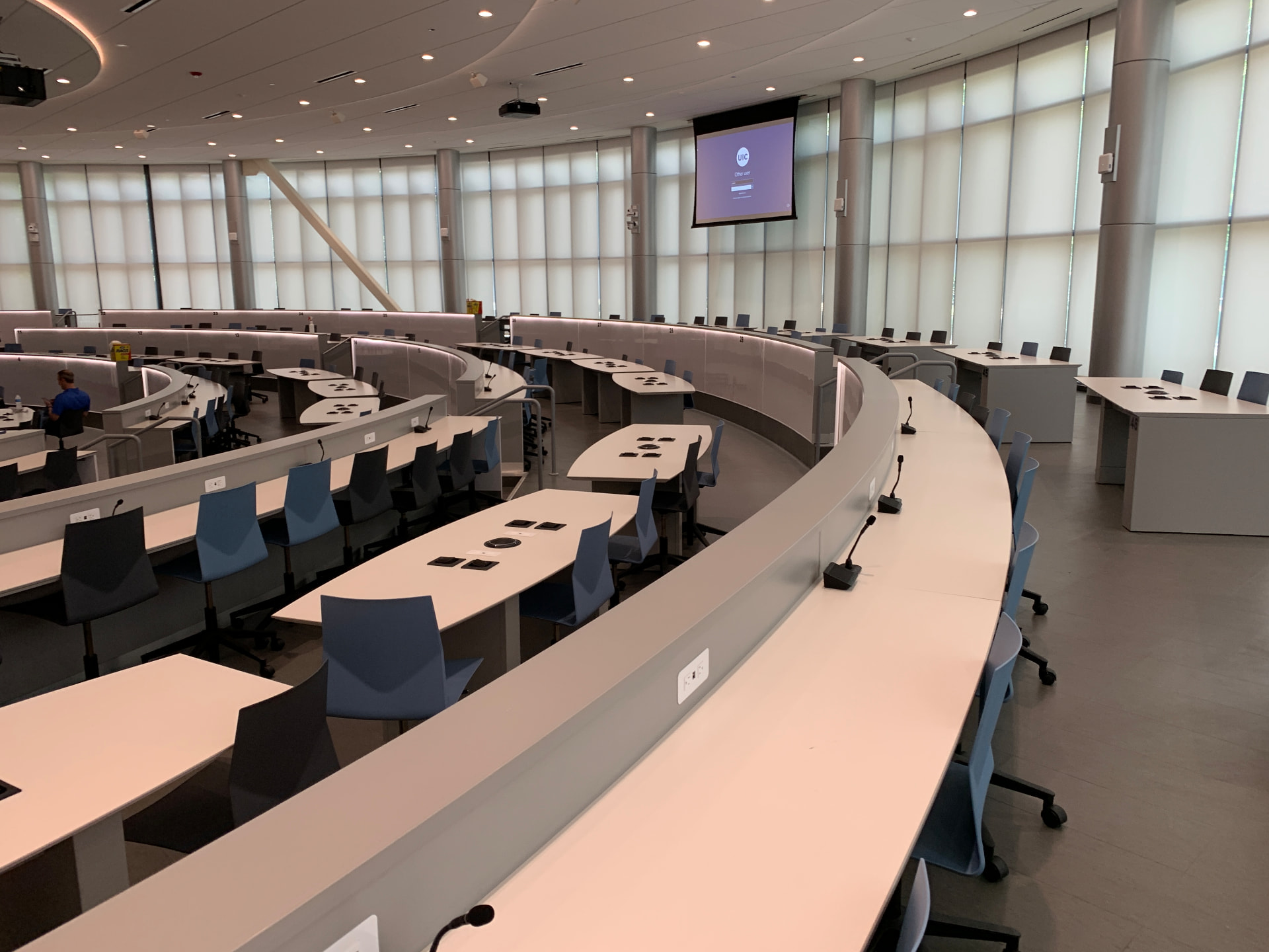 Tiered active-learning lecture hall with delegate microphones at every seat.