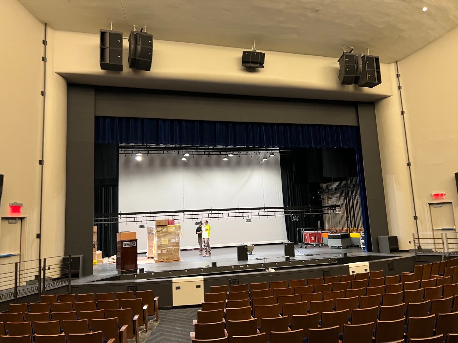 Main and side-fill loudspeaker arrays flown at the proscenium during installation.