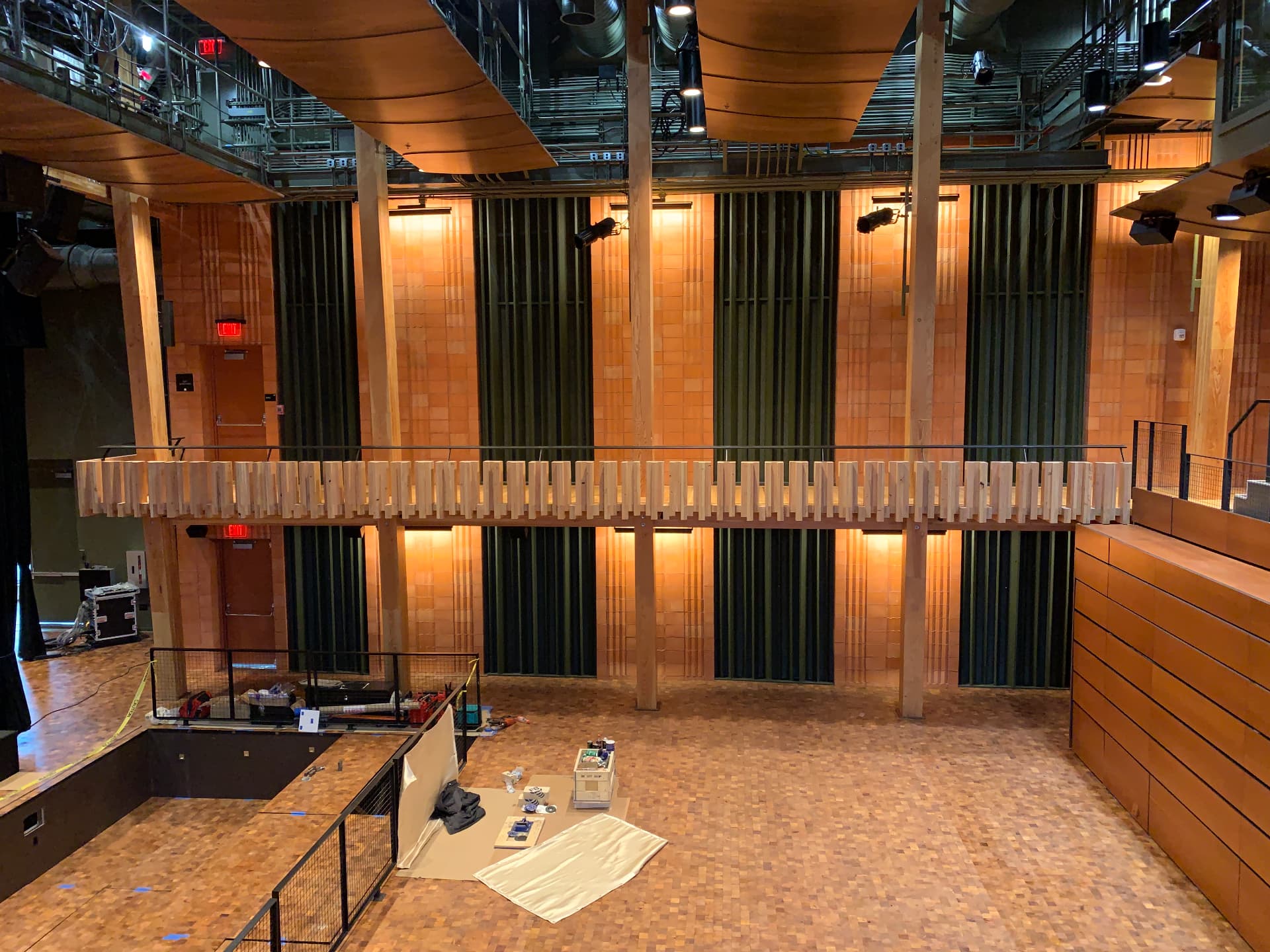 Flexible hall during fit-out, with side-wall treatment and mezzanine tech positions.