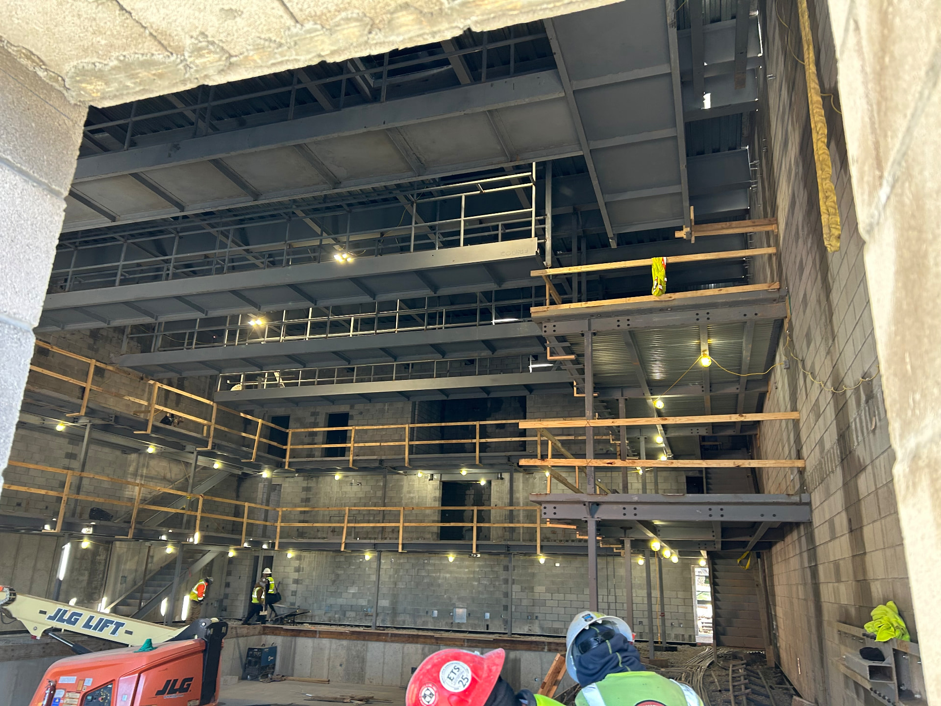 Construction phase — structural steel, catwalk levels, and rough-in for AV pathways and rigging points.