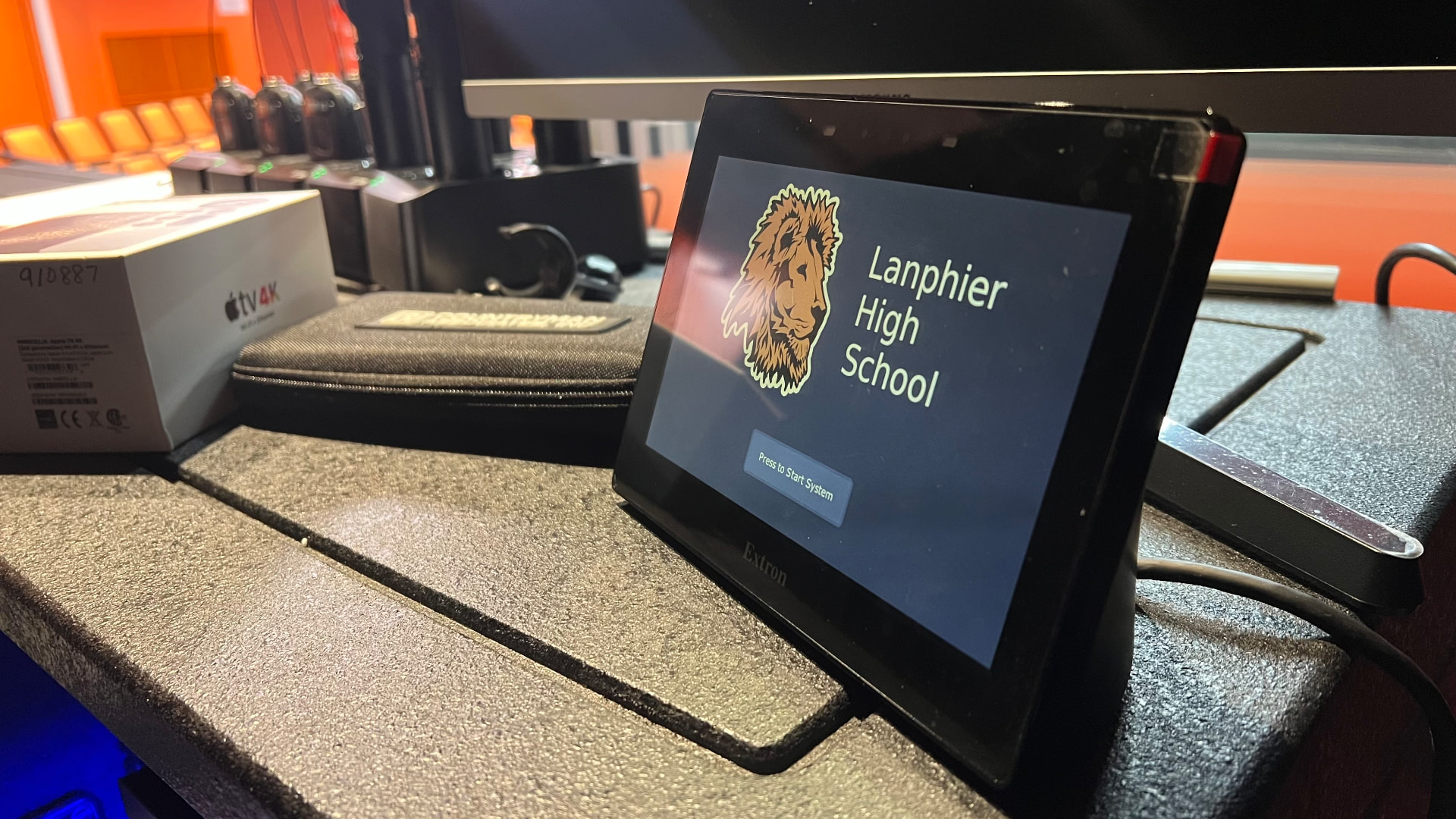 Extron touch panel with school branding — one-touch system startup for non-technical users.
