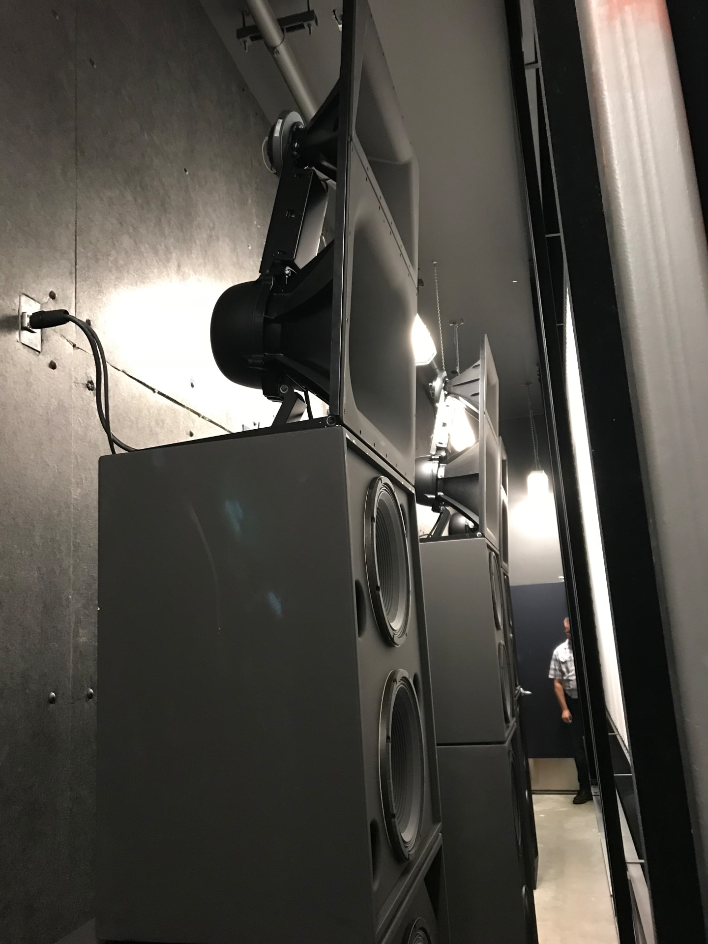 Screen-channel loudspeakers and subwoofers behind the cinema screen.