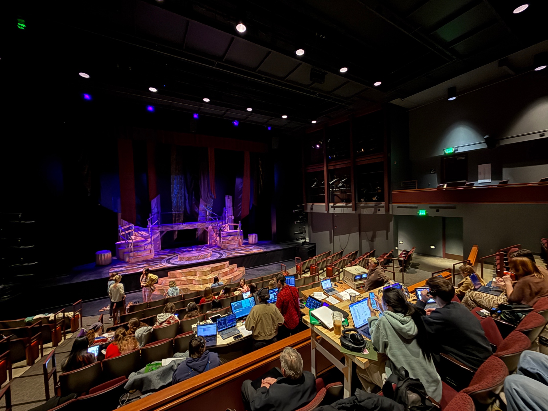 Cue-to-cue rehearsal in Purdue's Hansen Theatre with the design team at tech tables in the house.