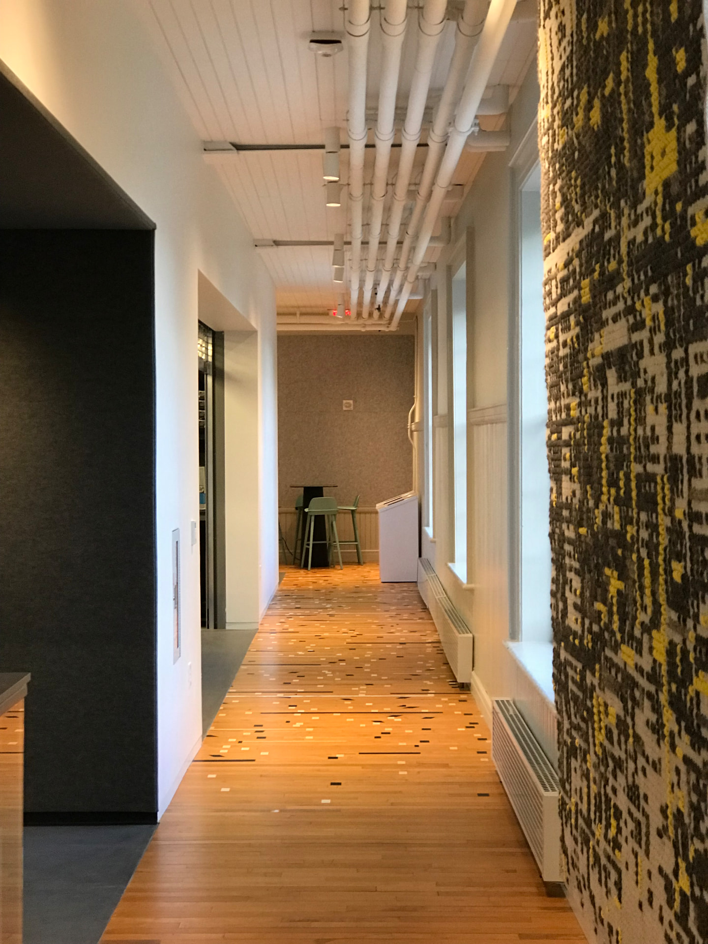 Circulation gallery linking studios, screening room, and maker spaces.