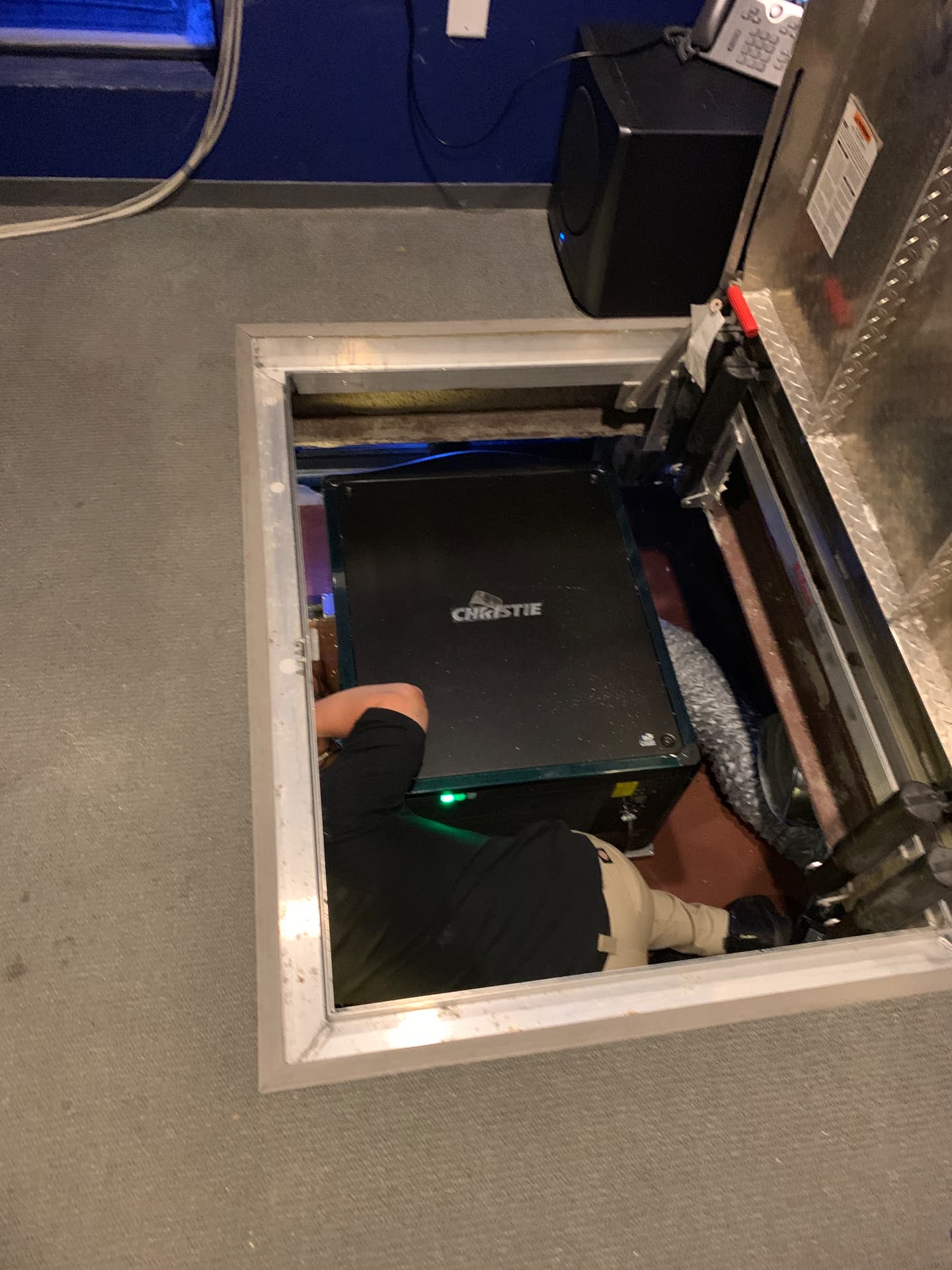 Cinema projector installation in the below-floor projection pit.